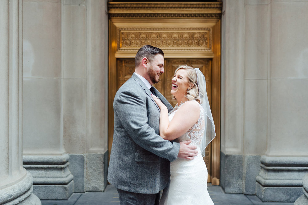 couple laughing together at their first look in the financial district of downtown chicago by nashville wedding photographer sara bill photography