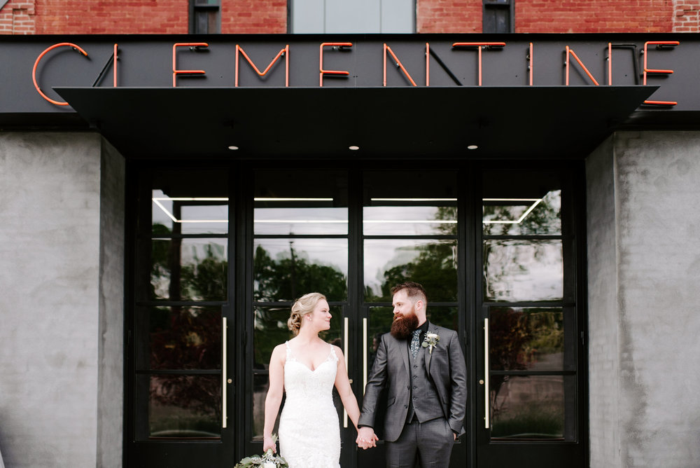 couple holding hands in front of clementine hall nashville wedding venue by nashville wedding photographer sara bill photography