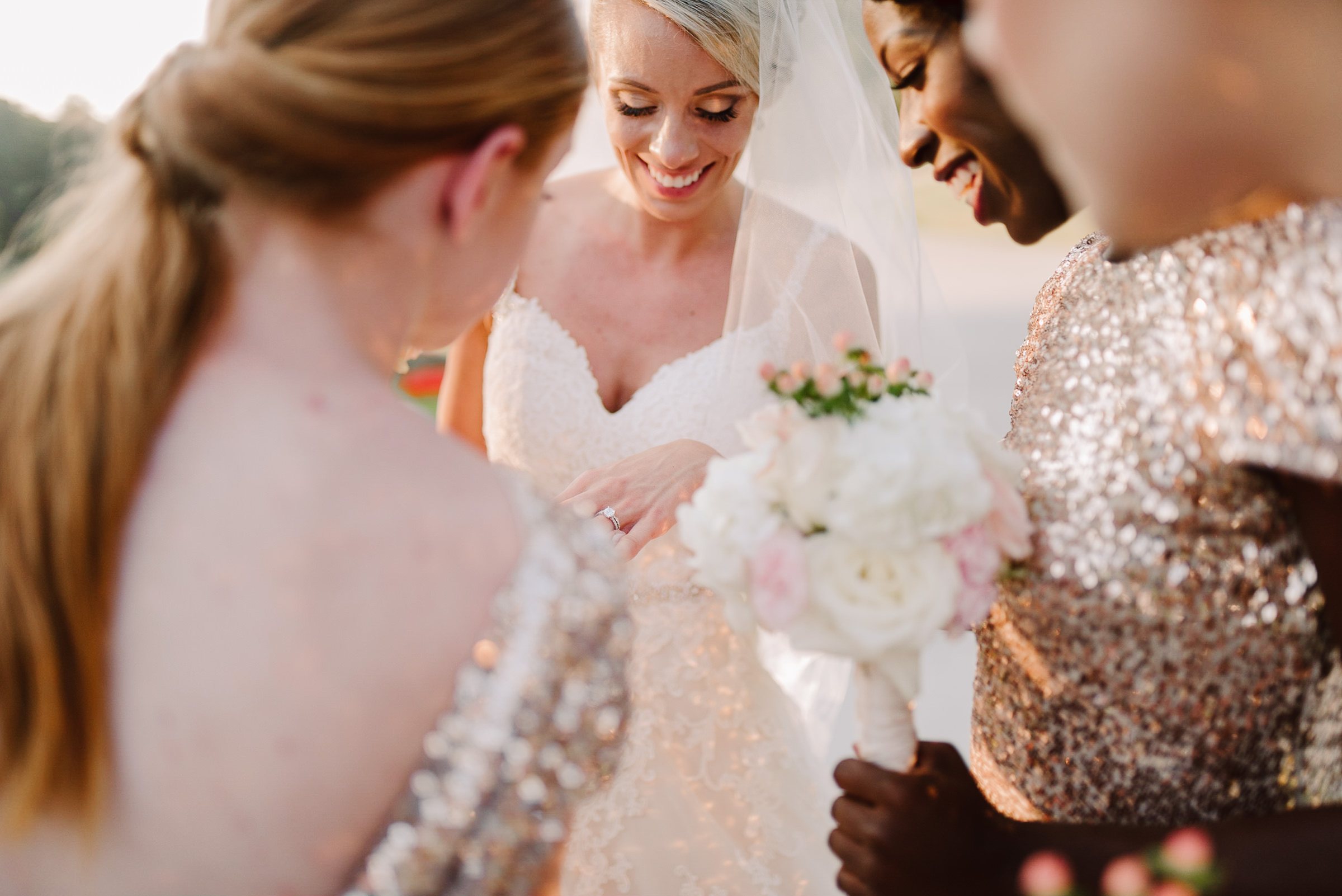 white dove barn happy bride showing off ring to bridesmaids after outdoor ceremony