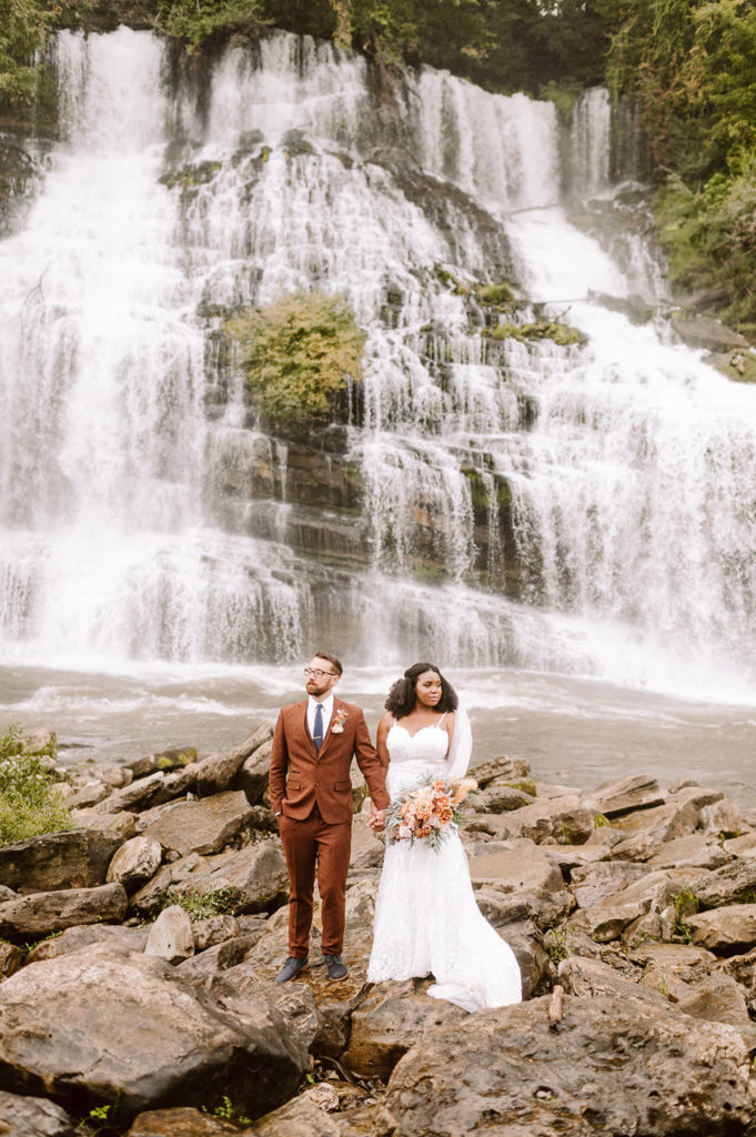 married couple standing in front of twin falls at rock island state park after their elopement