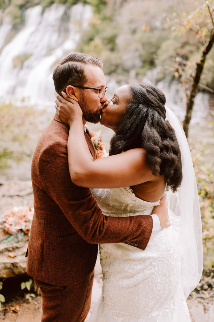 Couple kissing after their wedding ceremony at rock island state park in front of twin falls